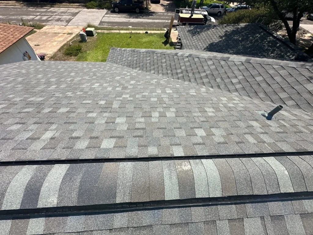 New gray architectural shingle roof with ridge vent, hip caps, and new pipe boots in Cedar Park, TX