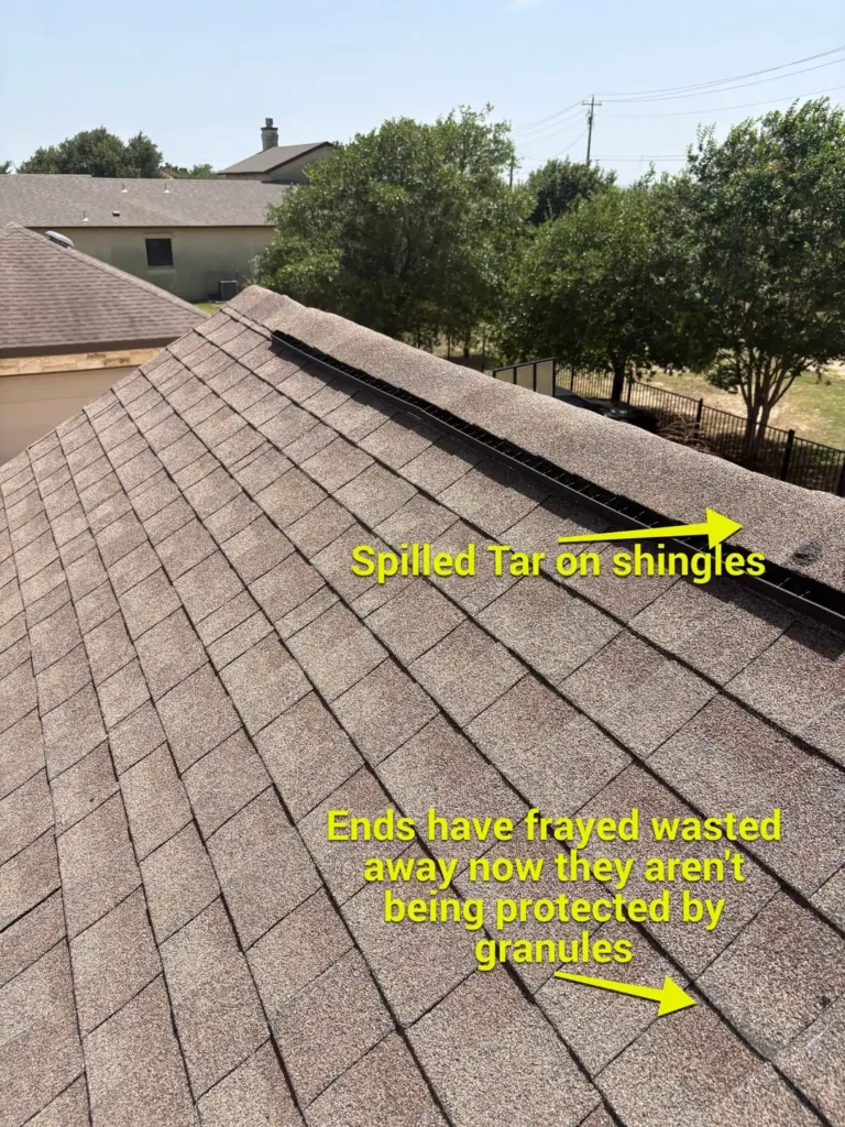 Aging roof slope with frayed shingle ends and spilled tar from an old repair near the ridge vent in Liberty Hill, TX