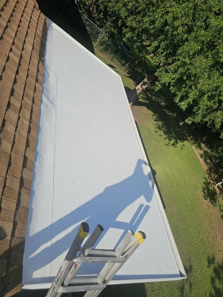 New white membrane on a low-slope roof section next to new shingles on a Georgetown, TX home