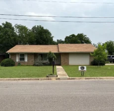 Brick ranch home in Georgetown, TX with a new tan shingle roof after a full roof replacement