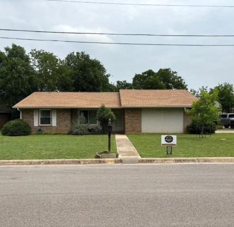 Brick ranch home in Georgetown, TX with a new tan shingle roof after a full roof replacement