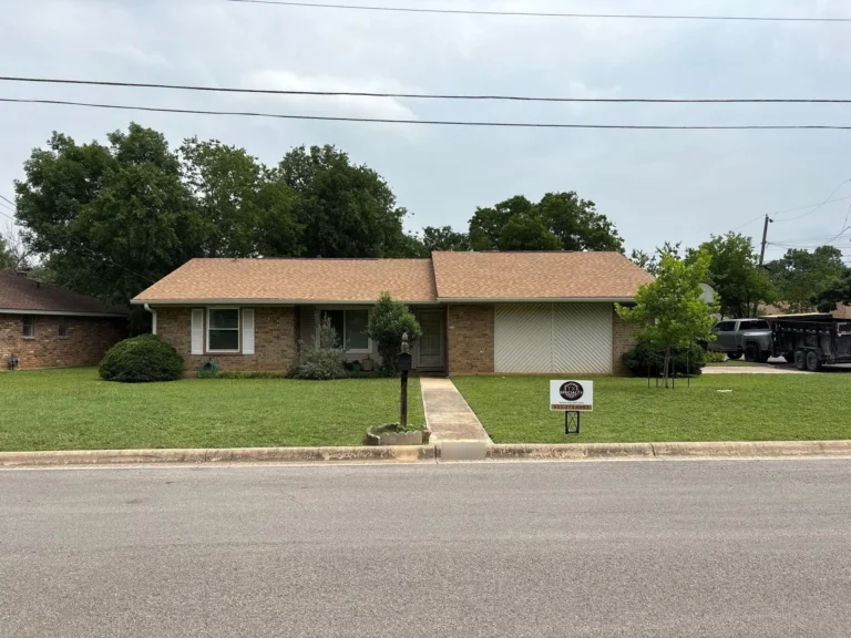 Brick ranch home in Georgetown, TX with a new tan shingle roof after a full roof replacement