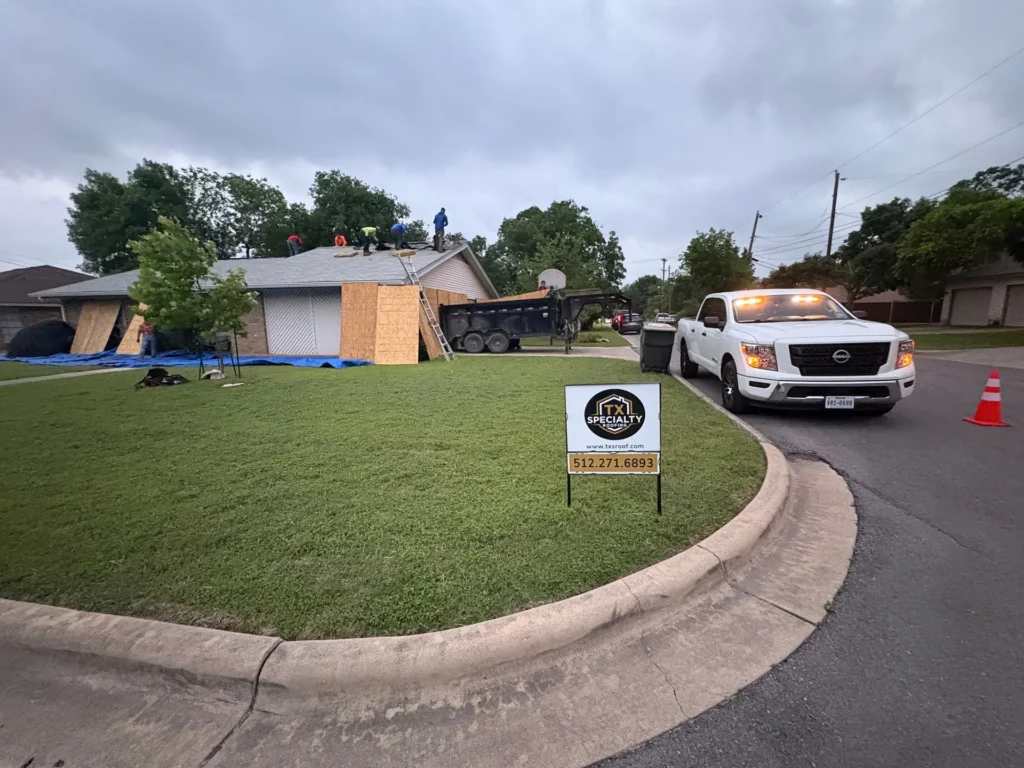 TX Specialty Roofing crew working on a roof replacement in Georgetown, TX with plywood over the windows and garage door