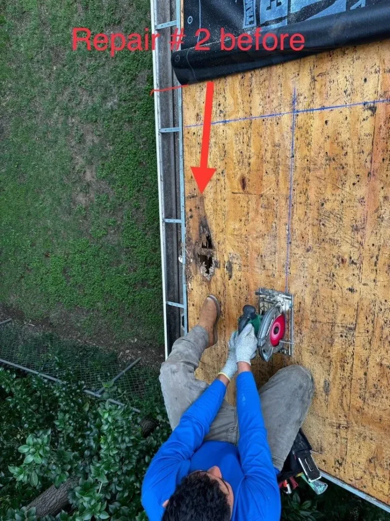 Roofer cutting out a rotted section of roof decking at the eave during a roof replacement in Georgetown, TX