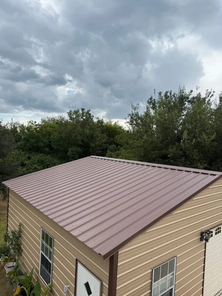 Detached garage with a new brown corrugated metal roof and matching trim in Helotes, TX