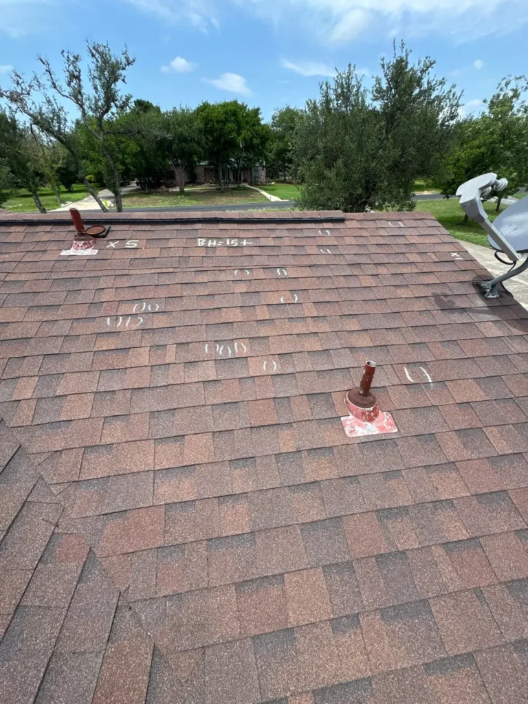 Hail hits circled in chalk and a slope marked BH=15+ during a roof inspection in Helotes, TX 78023