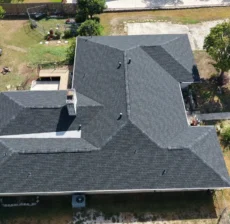 Overhead drone view of the rear hip roof and chimney after a full tear-off in Helotes, TX