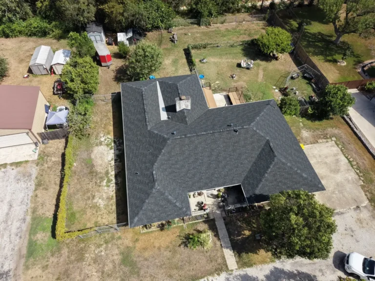 Aerial view of a new charcoal shingle roof on a Helotes home after hail damage roof replacement