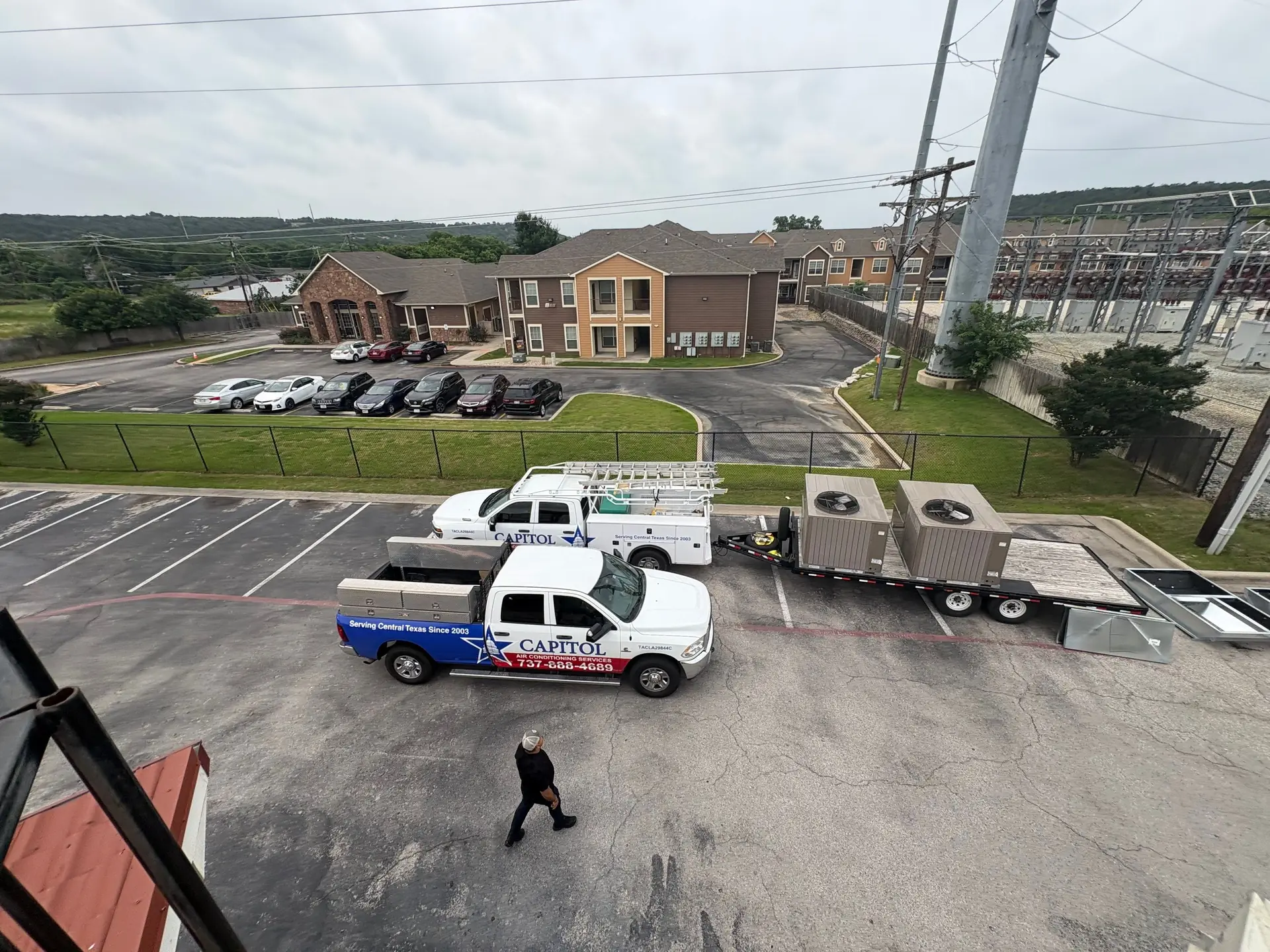 New rooftop HVAC units on a trailer in a restaurant parking lot, ready to be lifted onto the new flat roof