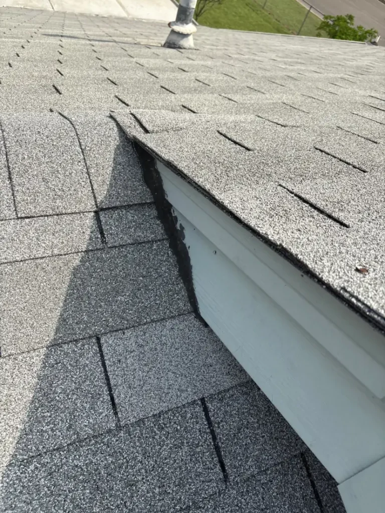 Raised flashing at the edge of an asphalt shingle roof section