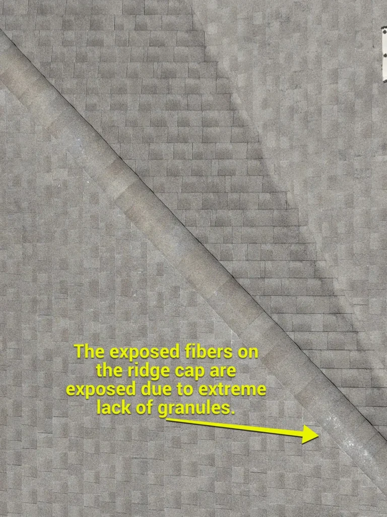 Ridge cap shingles with severe granule loss and exposed fibers on an aging roof in Liberty Hill, TX