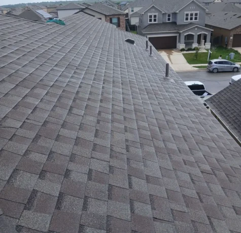 New architectural shingle roof with new pipe vents on a two-story home in Uhland, TX after hail damage roof replacement