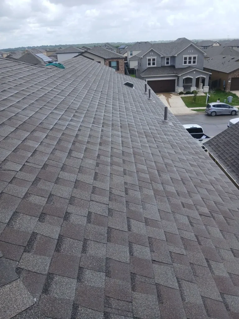 New architectural shingle roof with new pipe vents on a two-story home in Uhland, TX after hail damage roof replacement
